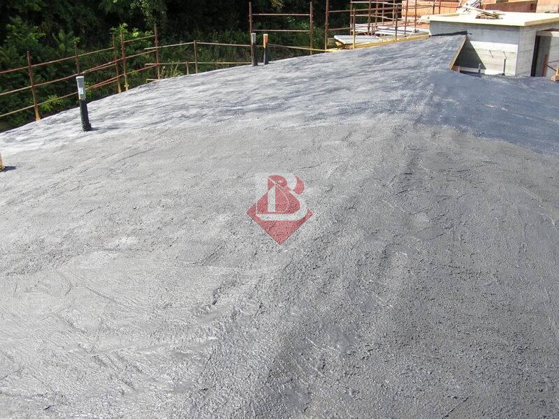 Vista di un tetto a Brescia appena impermeabilizzato con una membrana liquida bituminosa. La superficie è completamente rivestita per garantire protezione contro le infiltrazioni d'acqua e durabilità nel tempo. Il tetto, ancora in fase di costruzione, mostra l'efficacia dell'impermeabilizzazione realizzata da Isolamenti Bertoni.