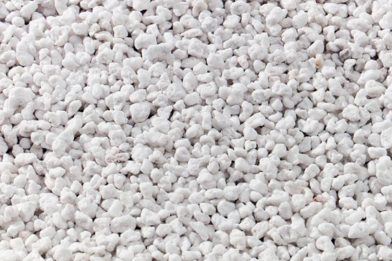 Vista ravvicinata di granuli di perlite utilizzati per l'insufflaggio in pareti e intercapedini per l'isolamento termico a Mantova. La perlite è un materiale naturale che migliora l'efficienza energetica degli edifici, riducendo la dispersione di calore e migliorando il comfort abitativo.