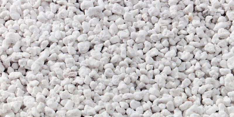 Vista ravvicinata di granuli di perlite utilizzati per l'insufflaggio in pareti e intercapedini per l'isolamento termico a Mantova. La perlite è un materiale naturale che migliora l'efficienza energetica degli edifici, riducendo la dispersione di calore e migliorando il comfort abitativo.