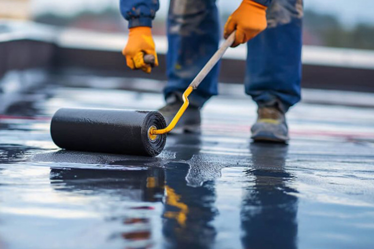 Operaio durante l’applicazione di una membrana liquida bituminosa su tetto piano a Modena, con rullo manuale per impermeabilizzazione continua e resistente all’acqua.